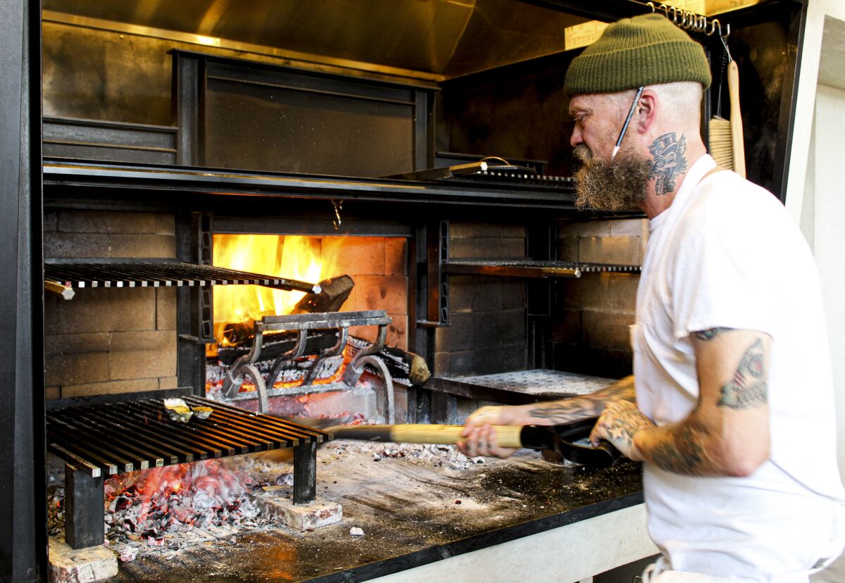 Chef Brian Dunsmoor tends to his restaurant's hearth oven.