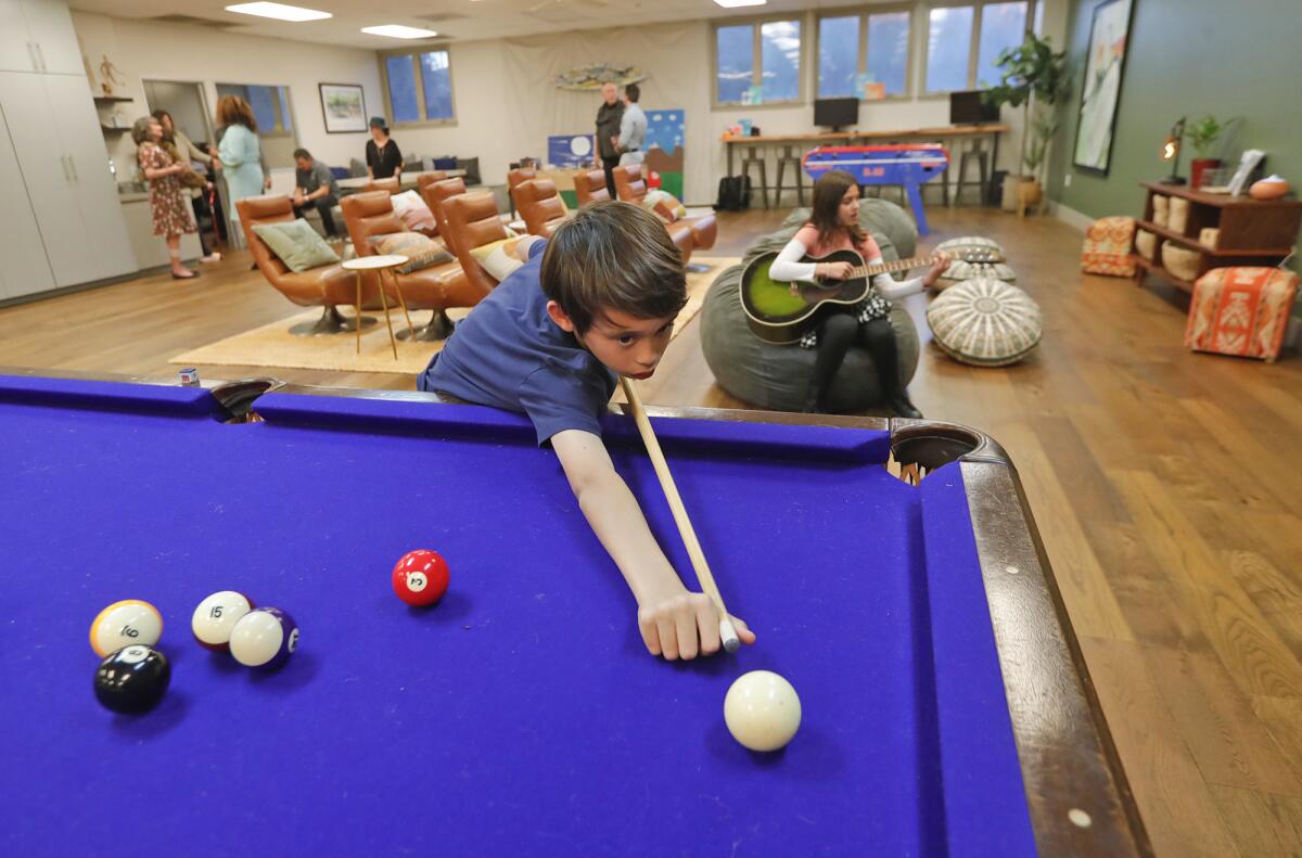 Oliver Bishop plays on the new pool table as part of the new well space room.