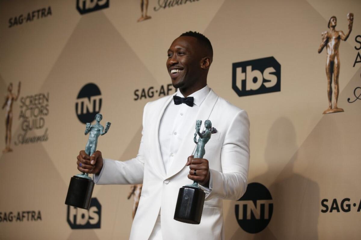 Mahershala Ali holds the two trophies he won at this year's SAG Awards.