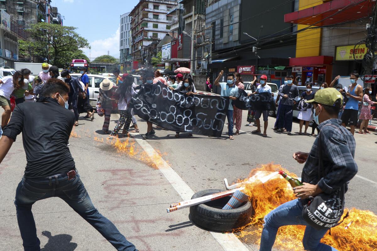 Anti-coup protesters burn tires and chant slogans with banner read ''The Kamayut strike will be fight for to the end when we get victory" during the demonstration against the military coup in Kamayut township Yangon, Monday, May 3, 2021. (AP Photo)