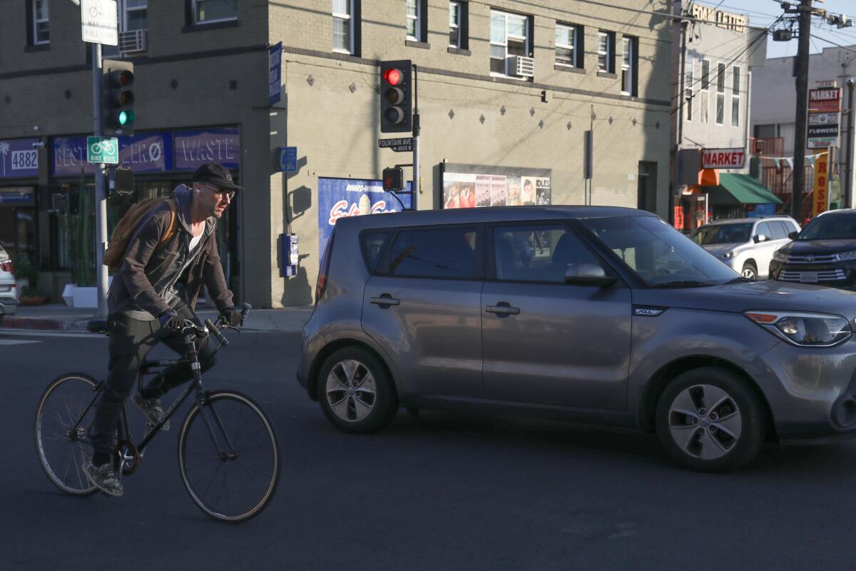 A cyclist rides in traffic.