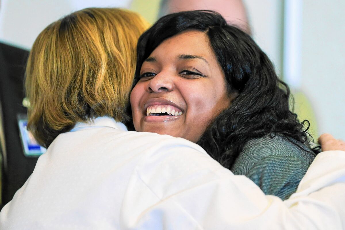 Amber Vinson, the second Dallas nurse to be declared Ebola-free after contracting the disease while treating a patient, embraces a member of her nursing team upon leaving Emory University Hospital in Atlanta on Tuesday.
