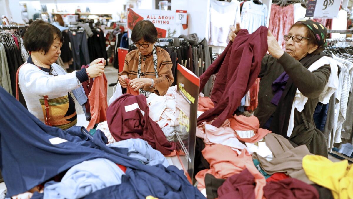 Shoppers rummage through tops on Black Friday at JCPenney at the Glendale Galleria.
