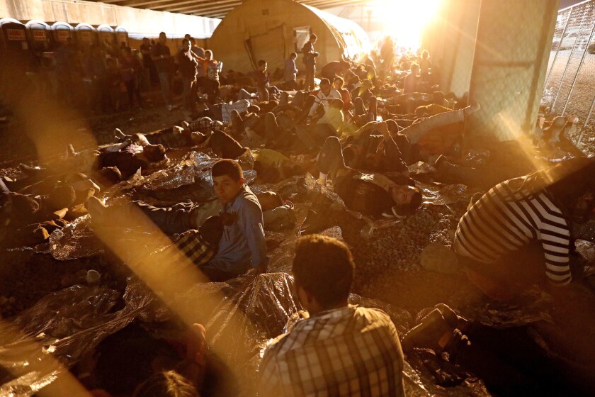 Hundreds of migrants seeking asylum are held in a temporary transition area under the Paso del Norte bridge in El Paso.