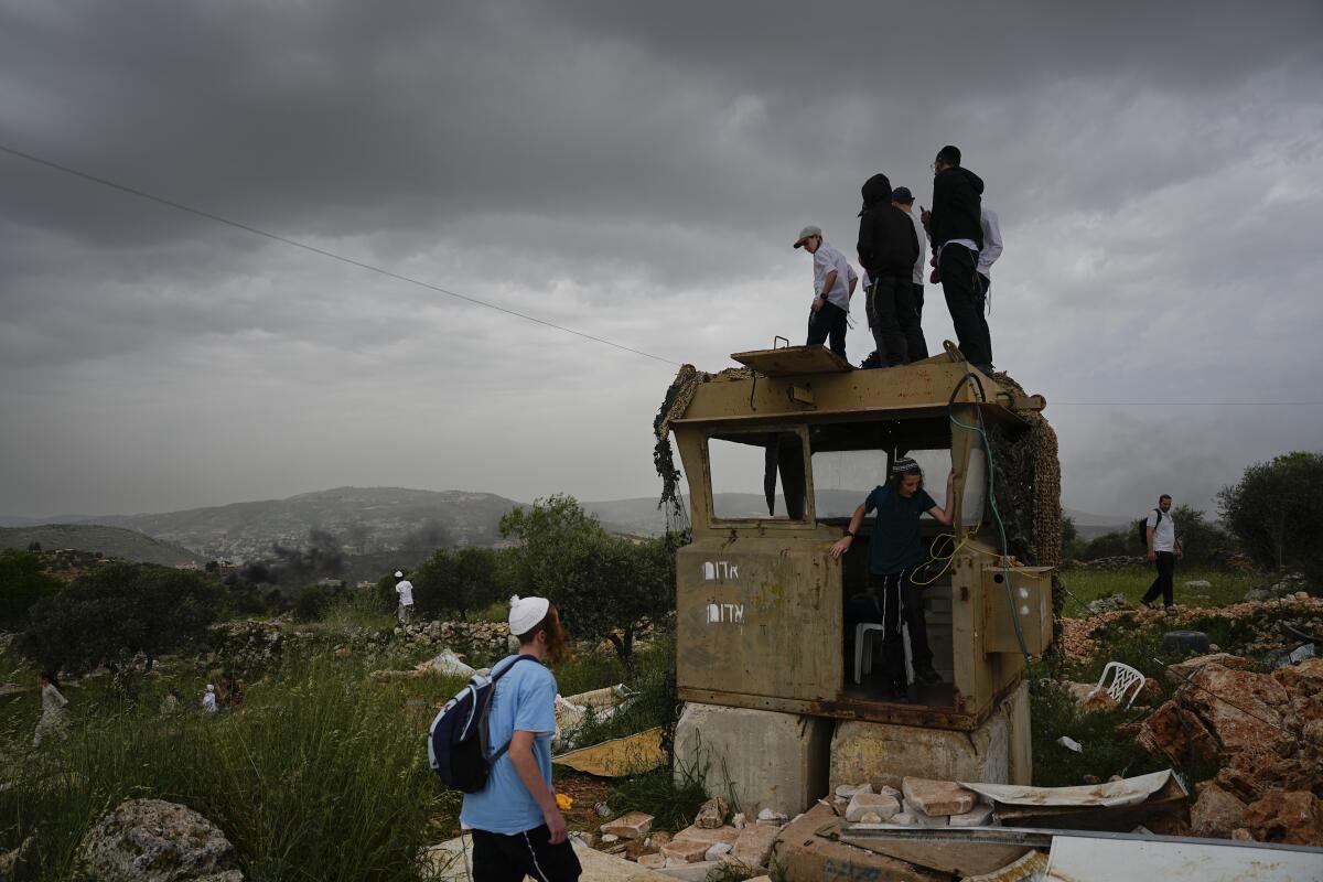 Israeli settlers stand in the outpost of Eviatar in the West Bank on Monday.