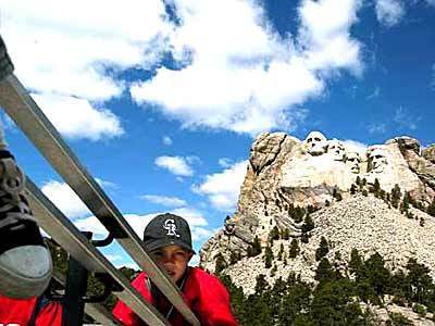 Colin Gossin, 10, slides down a banister at Mt. Rushmore National Memorial in South Dakota, where Gutzon Borglum and others carved the faces of Washington, Jefferson, Theodore Roosevelt and Lincoln.