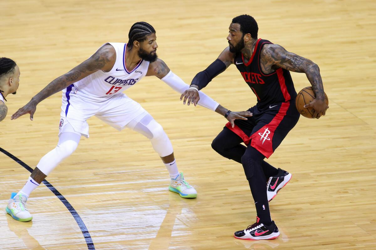 Rockets guard John Wall looks to drive against Clippers forward Paul George.