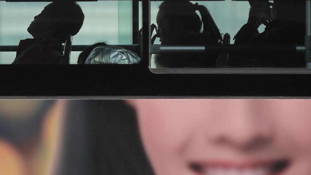 Commuters ride a bus in Beijing's central business district this month.