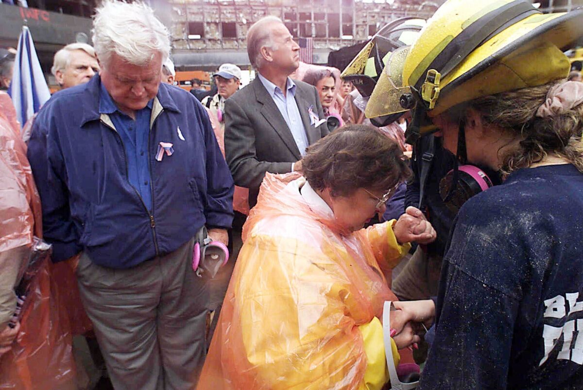 FILE - In this Sept. 20, 2001, file photo Sen. Ted Kennedy, D-Mass., left, and Sen. Joe Biden, center, stand by as Sen. Barbara Mikulski, D-Md., in orange parka, joins in prayer with rescue workers at the site of the World Trade Center in New York. They were part of a delegation of Senators that traveled by train to New York to view the rubble that once was the World Trade Center. The terrorist attacks that day shattered Americans’ sense of security and ushered in a new era of nebulous threats, hidden enemies and a seemingly never-ending war on terror. And for then-Sen. Joe Biden they marked a new phase of his public life. (AP Photo/Mike Albans, Pool, File)