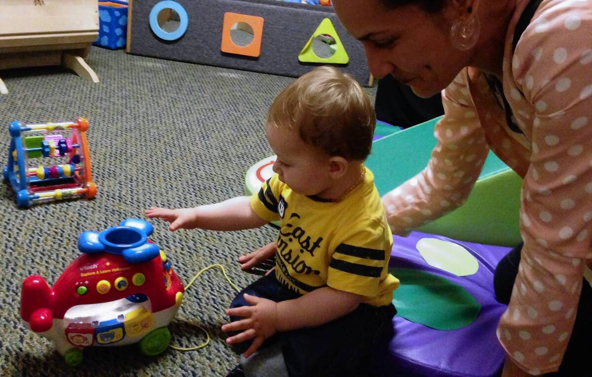 Single mother Beth Capper plays with her son Ezekiel Goss, 11 months, at the Children's Institute Inc.'s Mid-Wilshire campus. Capper has struggled to pay for diapers. "There's no way around buying them," she said.