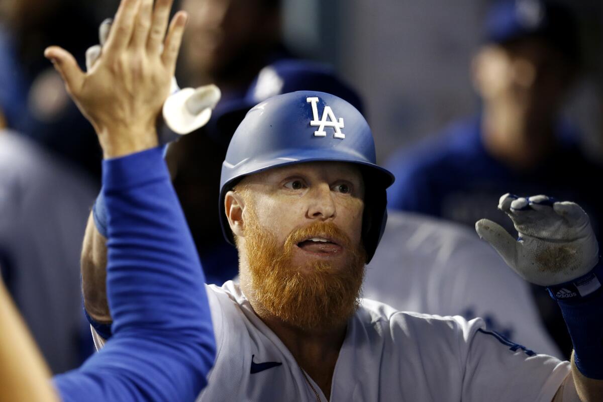 Dodgers third baseman Justin Turner celebrates with teammates in the dugout.