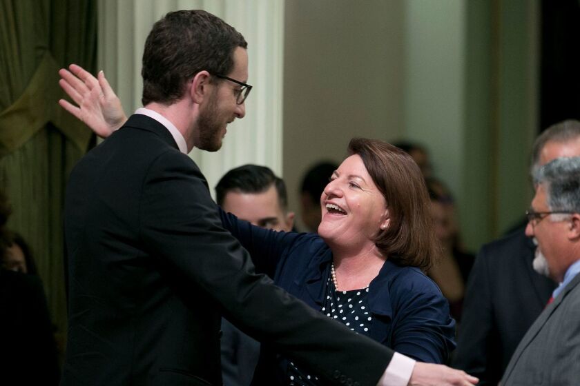 State Sen. Toni Atkins, D-San Diego, receives congratulations from Sen. Scott Wiener, D-San Francisco, after her housing measure was approved by the state Assembly, Thursday, Sept. 14, 2017, in Sacramento, Calif. The California Assembly has approved a multi-bill package to address the state's affordable housing crunch. The bills all need Senate approval on Friday. (AP Photo/Rich Pedroncelli)