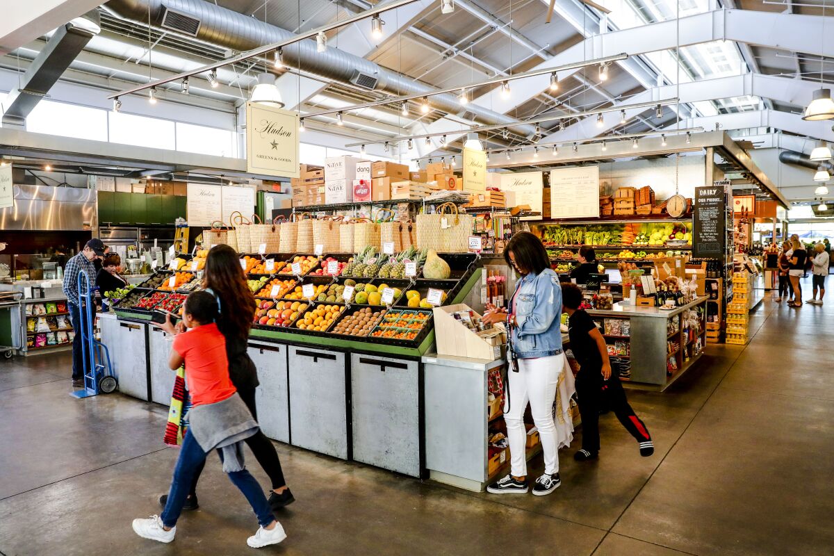 People browse food stands inside the Oxbow Public Market.