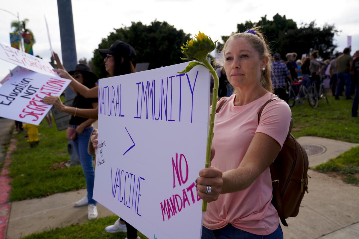 Alyssa Titus holds a sign at rally protesting COVID-19 vaccine mandate.