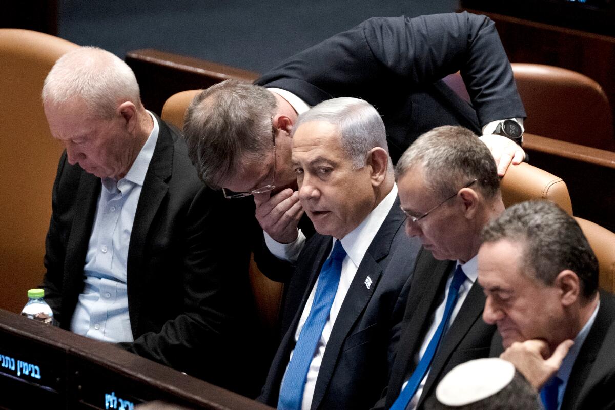 Lawmakers surround Israel's Prime Minister Benjamin Netanyahu in the Knesset.