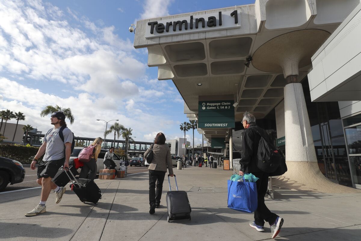 Travelers walk past Terminal 1 at the San Diego International Airport in 2020 in San Diego.