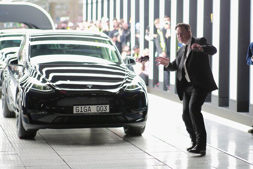 Tesla Chief Executive Elon Musk dances next to a car.