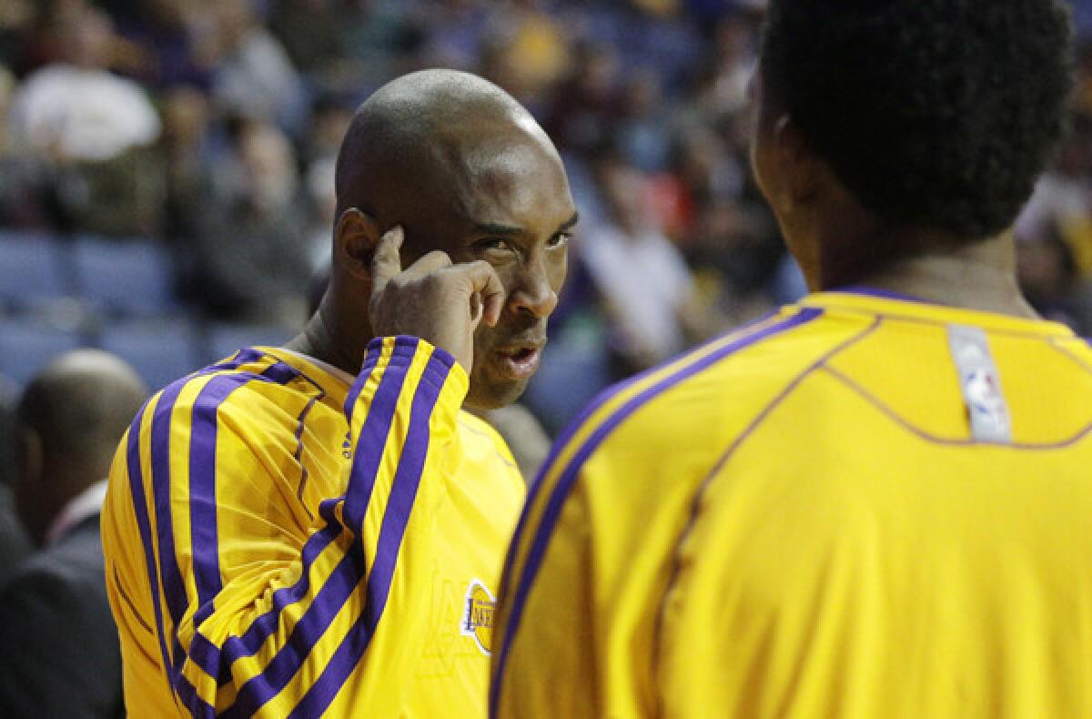 Lakers guard Kobe Bryant talks to teammate Nick Young before a preseason game.