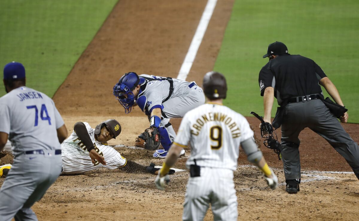 Padres' Trent Grisham is tagged out by Dodgers catcher Will Smith to end the game Wednesday at Petco Park.