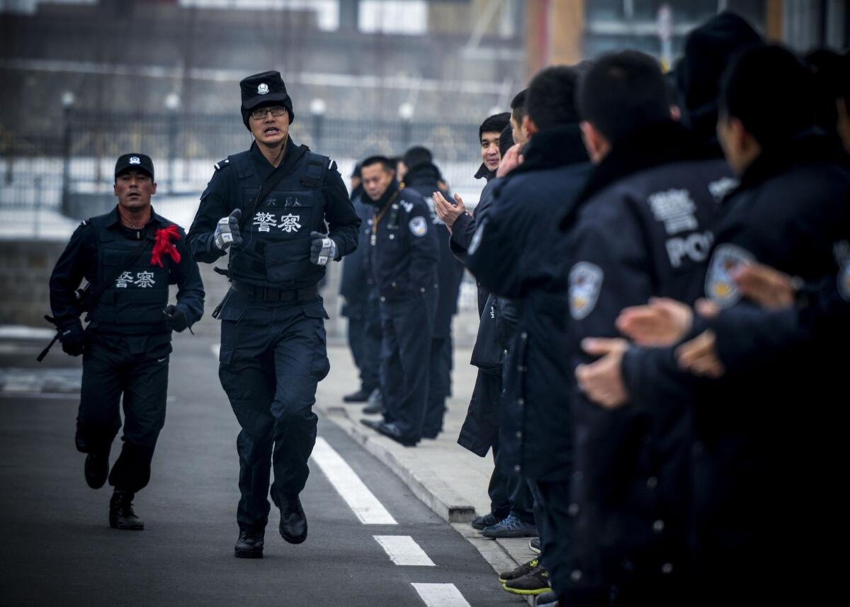 Two SWAT policemen run during a training competition in Urumqi in northwest China's Xinjiang region, where tension between law enforcement and Muslim Uighurs runs high.