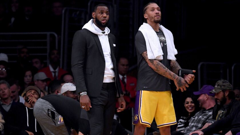 LeBron James and Michael Beasley look on from the bench during a Lakers' 130-111 loss to the Golden State Warriors at Staples Center on Monday.