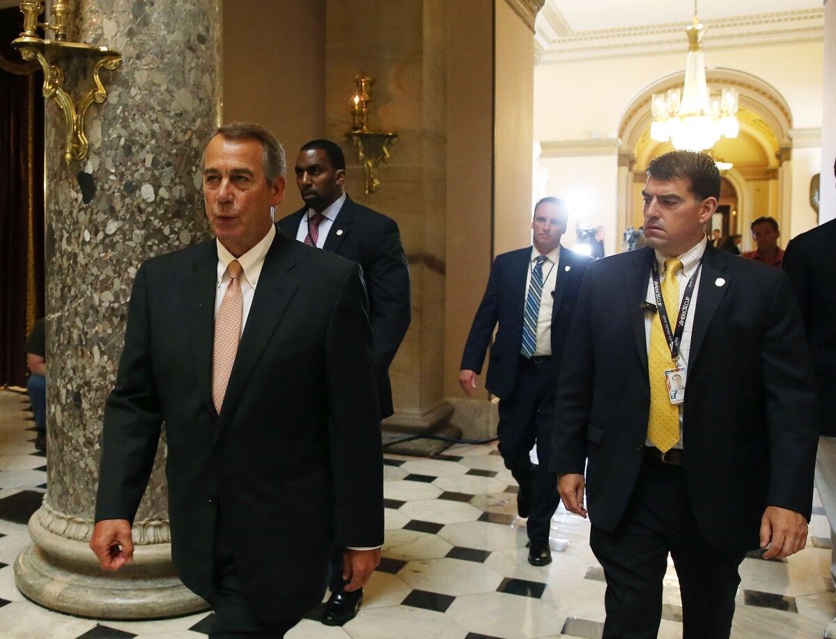 House Speaker John Boehner (R-Ohio), left, walks through the U.S. Capitol on Friday before a series of critical votes on fast-track trade legislation.