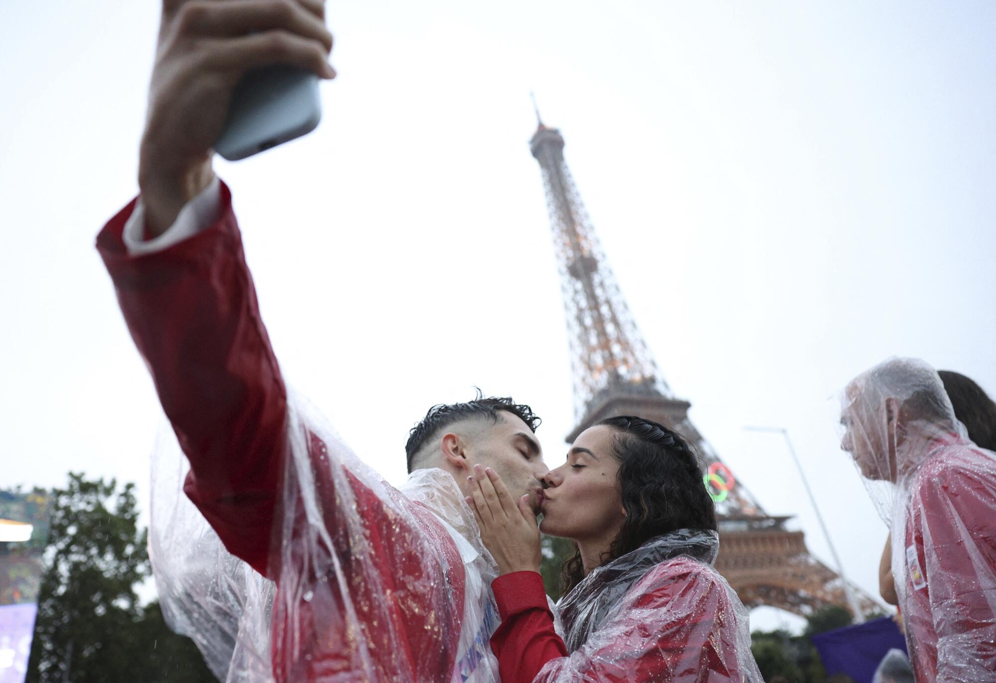 Spain athletes David Vega, left, and Noemi Romero kiss during the opening ceremony.