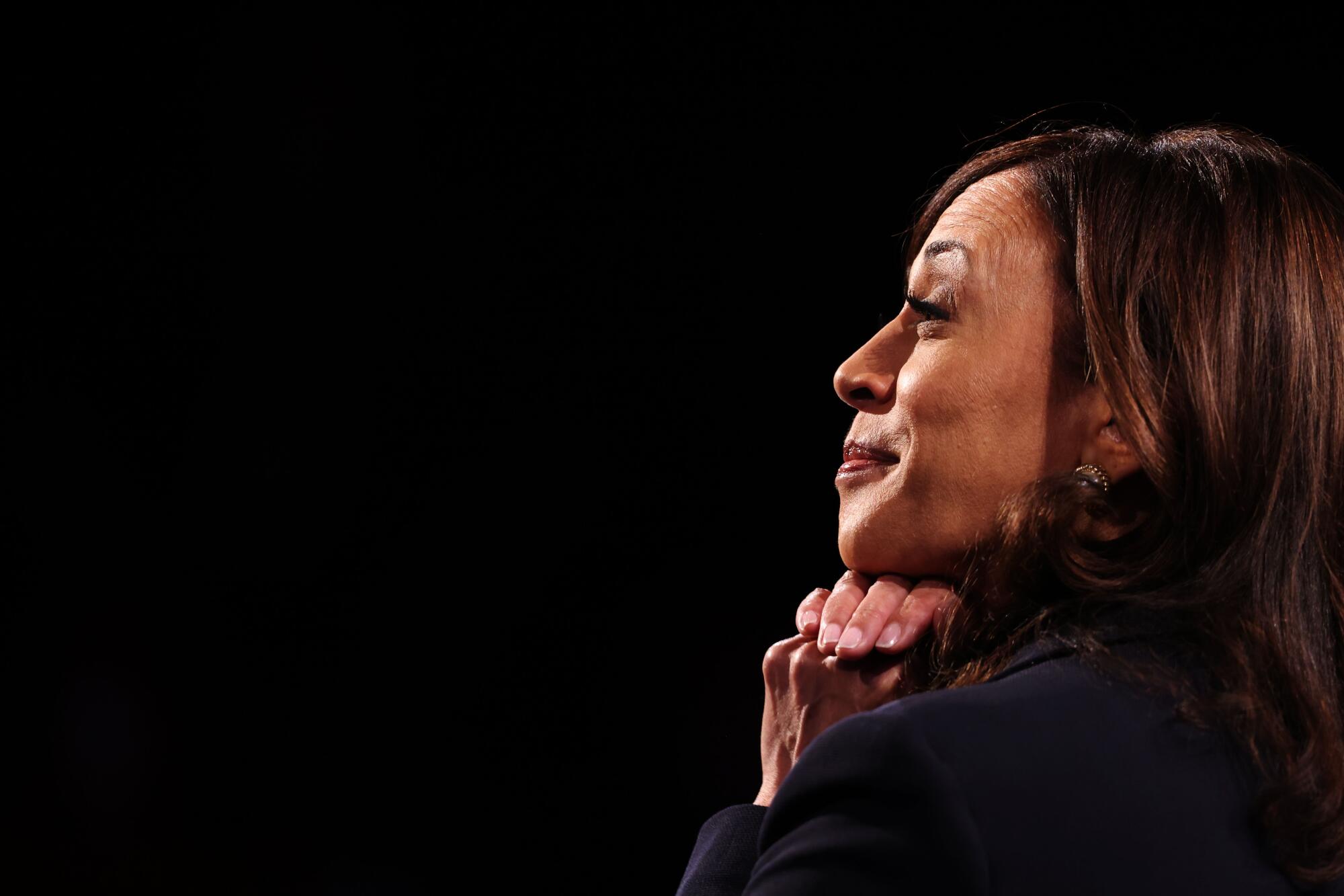 Kamala Harris smiles and places her hands under her chin