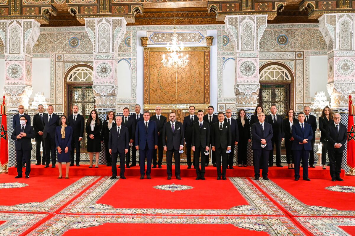 In this photo released by the Royal Palace, front row Morocco's King Mohammed VI, center, accompanied by the Crown Prince Moulay El Hassan, 4th right, and his brother Prince Moulay Rachid, 5th right, poses with all members of the new government of Morocco at the Royal Palace in Fez, Morocco, Thursday, Oct. 7, 2021. 4th left is the new prime minister Aziz Akhannouch the president of the National Rally of Independents party (RNI), winner of the legislative elections. (Moroccan Royal Palace via AP)