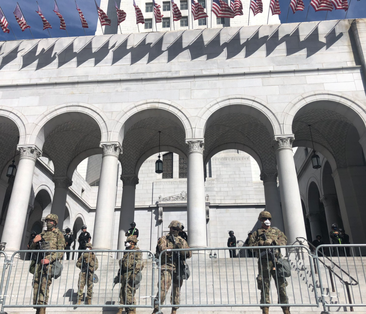 Members of the National Guard help LAPD officers patrol City Hall on Sunday.