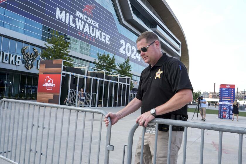 A United States Secret Service officer moves barricades outside the Fiserv Forum ahead of the 2024 Republican National Convention, Saturday, July 13, 2024, in Milwaukee. Former president Donald Trump was whisked off the stage at a rally in Butler, Pennsylvania after apparent gunshots rang through the crowd.(AP Photo/Morry Gash)