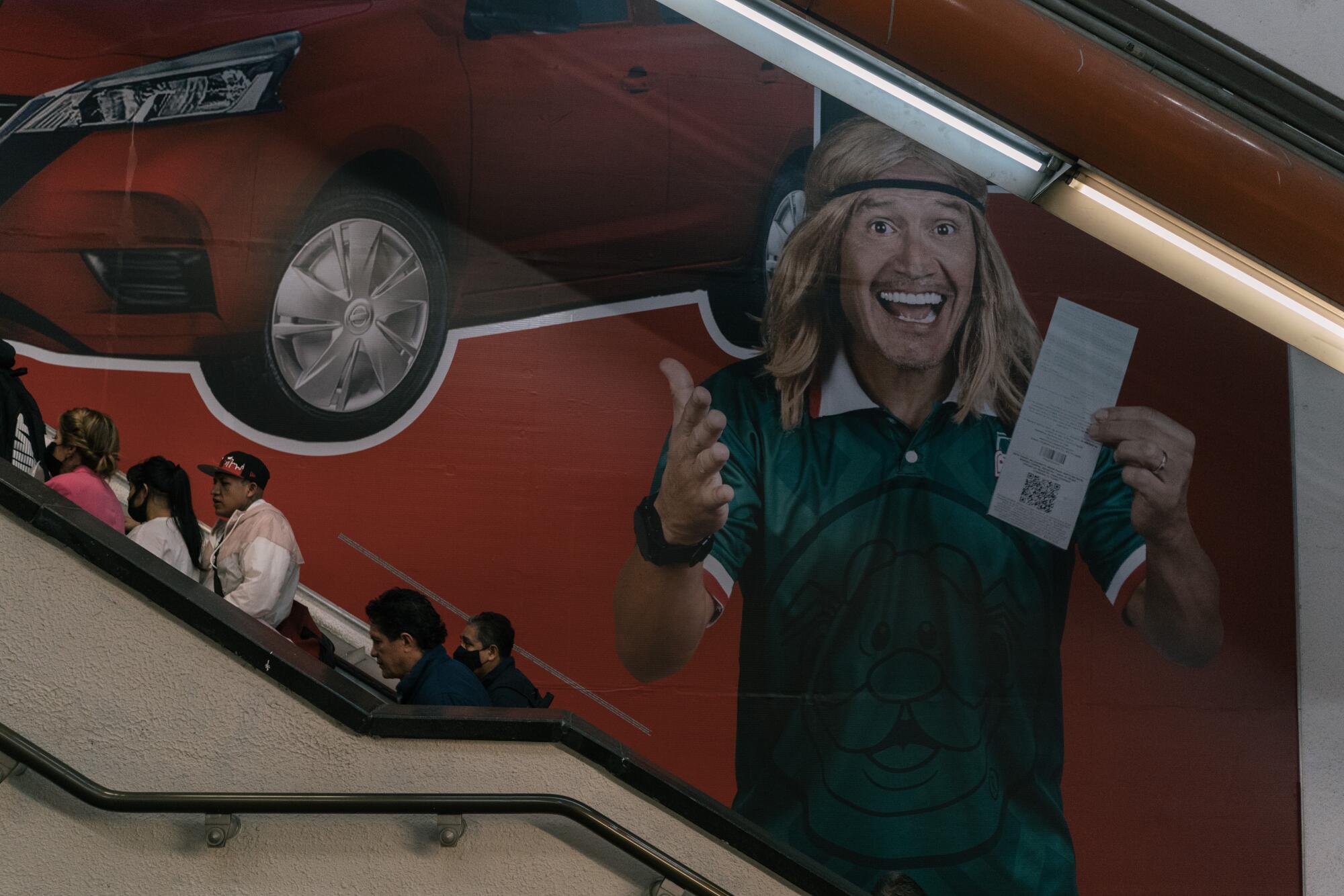 An ad near an escalator shows a man with blond hair and green shirt holding a piece of paper