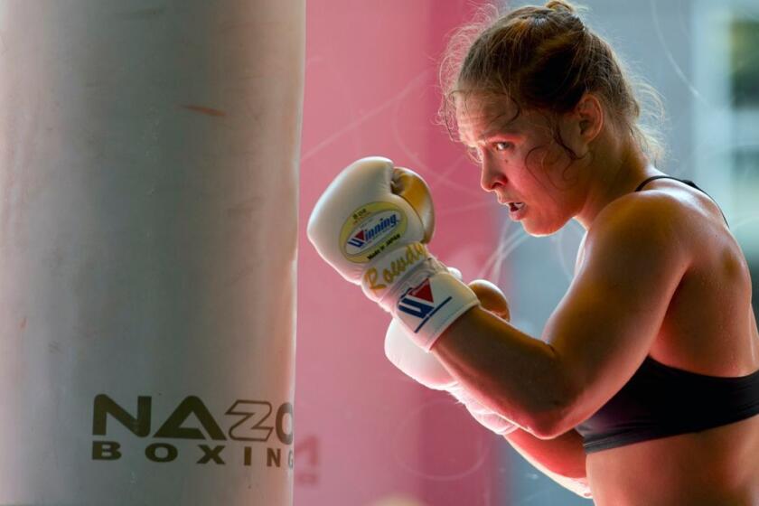 FILE - This July 15, 2015, file photo shows mixed martial arts fighter Ronda Rousey working out at Glendale Fighting Club in Glendale, Calif. The former UFC champion Rousey could soon make the move to WWE. Sheâs met with WWE executives and has seemed excited about the possibility of becoming a wrestler. Rousey may not debut at one of WWEâs signature events this weekend in Philadelphia because sheâs filming a movie in Colombia. (AP Photo/Jae C. Hong, File)