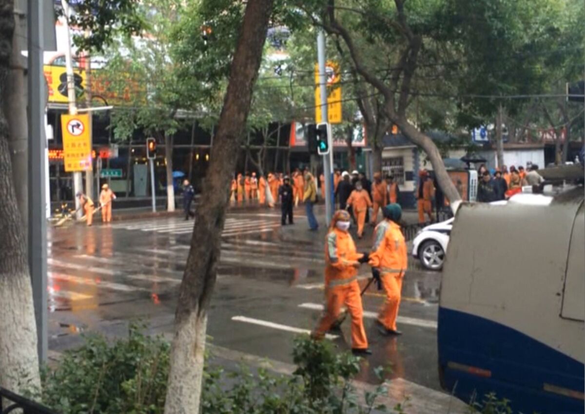 Cleaners clear a street in Urumqi after explosives killed at least 31 people.