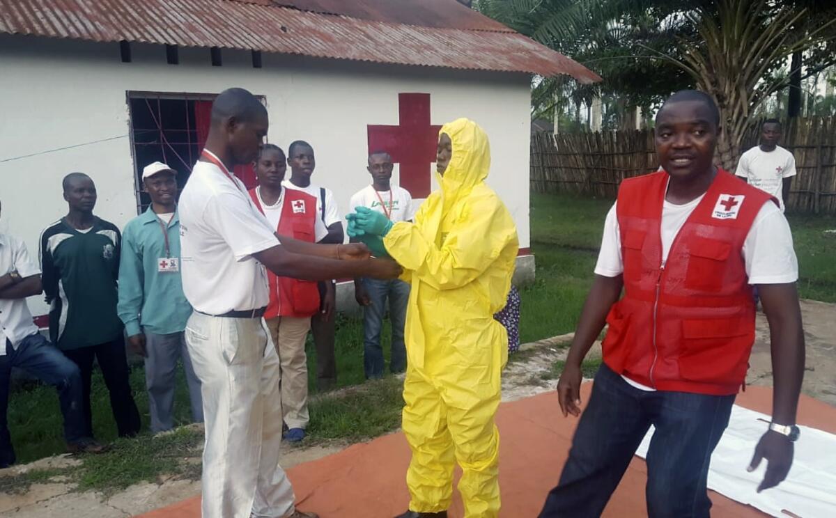En esta imagen, tomada el 14 de mayo de 2018, miembros de un equipo de la Cruz Roja se ponen un traje especial antes de atender a supuestos enfermos de ébola, en Mbandaka, Congo. (Karsten Voigt/Federación Internacional de la Cruz Roja y la Media Luna Roja vía AP)