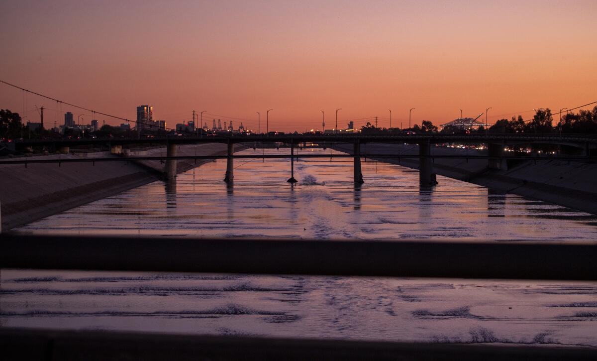 Bridges over the concrete-lined Los Angeles River at dusk