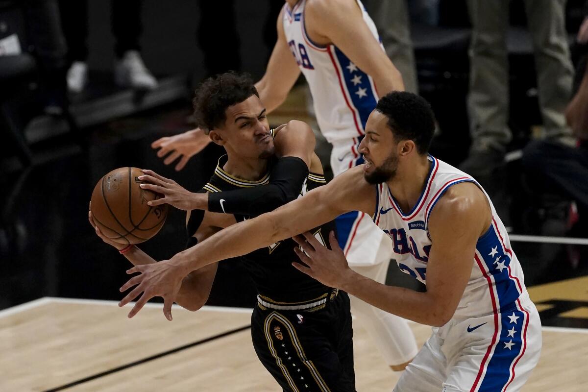 76ers forward Ben Simmons tries to steal the ball from Hawks guard Trae Young during a game last season.