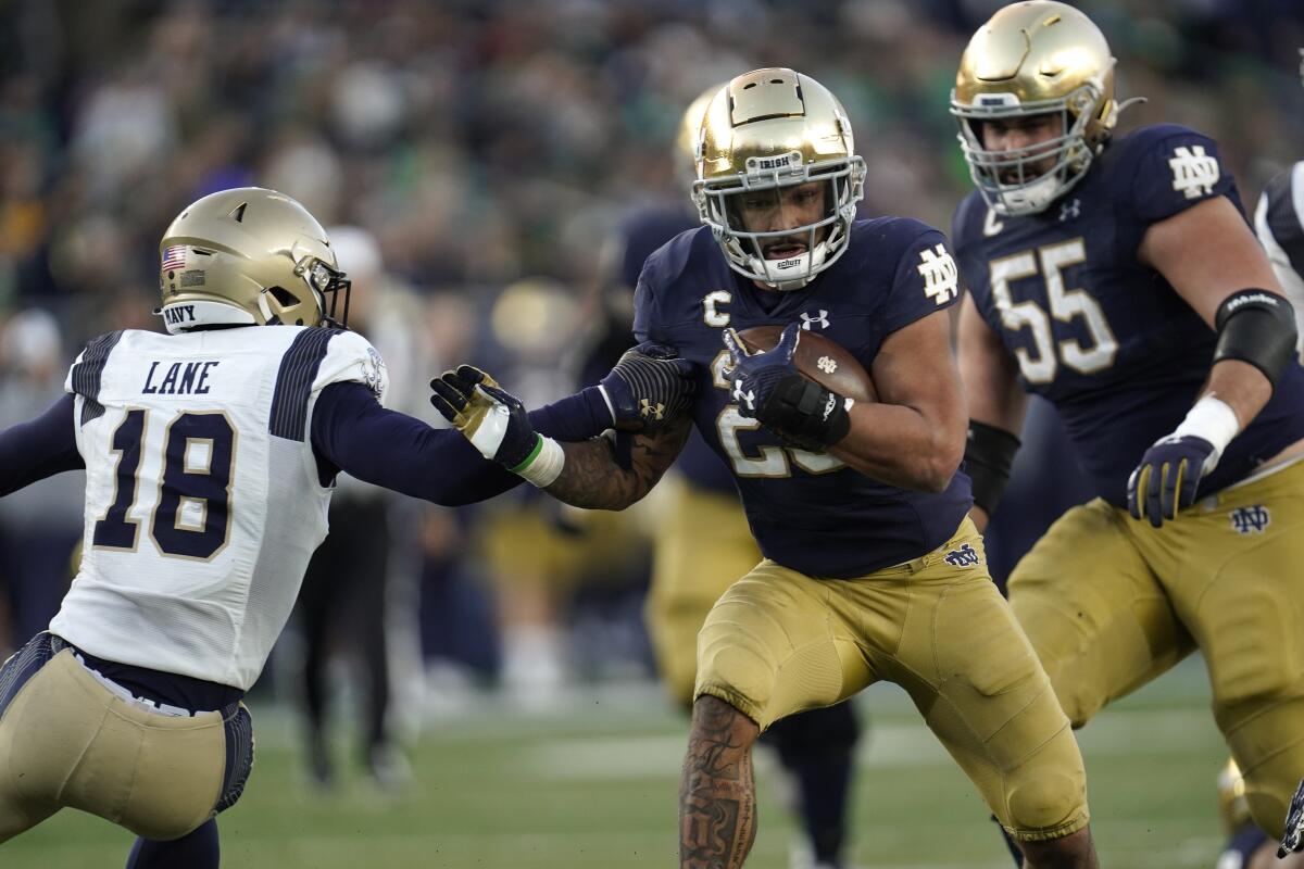 Notre Dame running back Kyren Williams gets past Navy safety Rayuan Lane for a 20-yard touchdown run Nov. 6, 2021. 