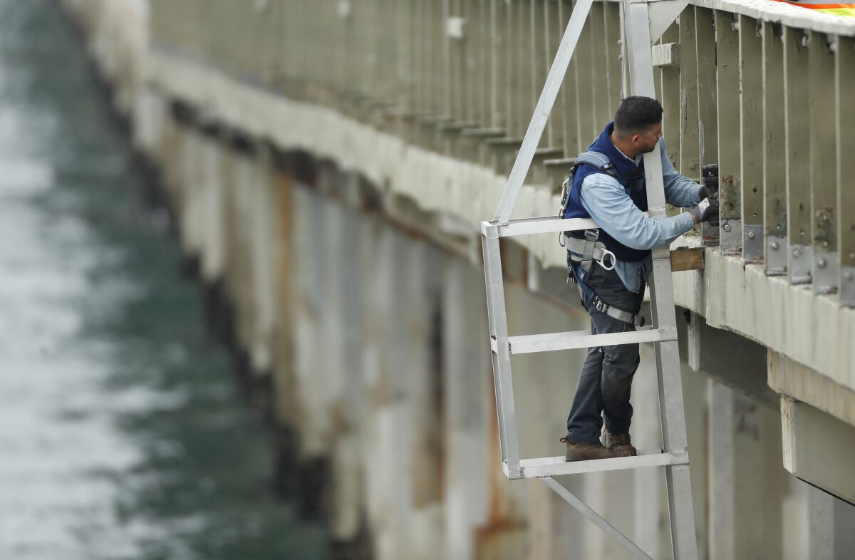 A San Diego city worker makes repairs on the Ocean Beach Pier on May 17. 