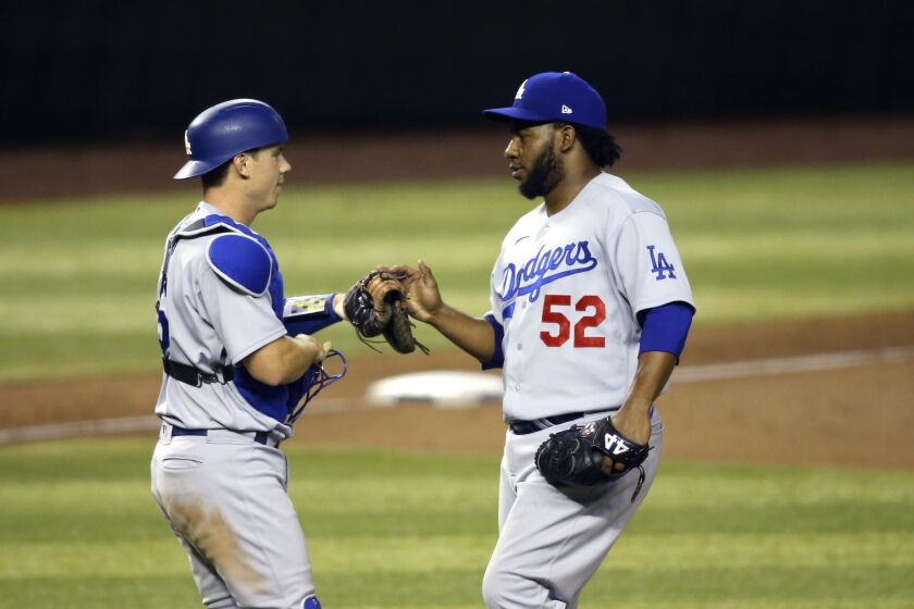 Los Angeles Dodgers relief pitcher Pedro Baez (52) celebrates with Dodgers catcher Will Smith, left, after the final out against the Arizona Diamondbacks during the ninth inning of the Diamondbacks' home opener baseball game Thursday, July 30, 2020, in Phoenix. The Dodgers defeated the Diamondbacks 6-3. (AP Photo/Ross D. Franklin)