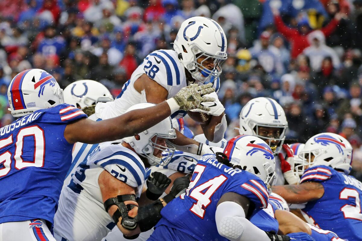 Indianapolis Colts running back Jonathan Taylor dives over the Buffalo Bills' defensive line to score a touchdown.