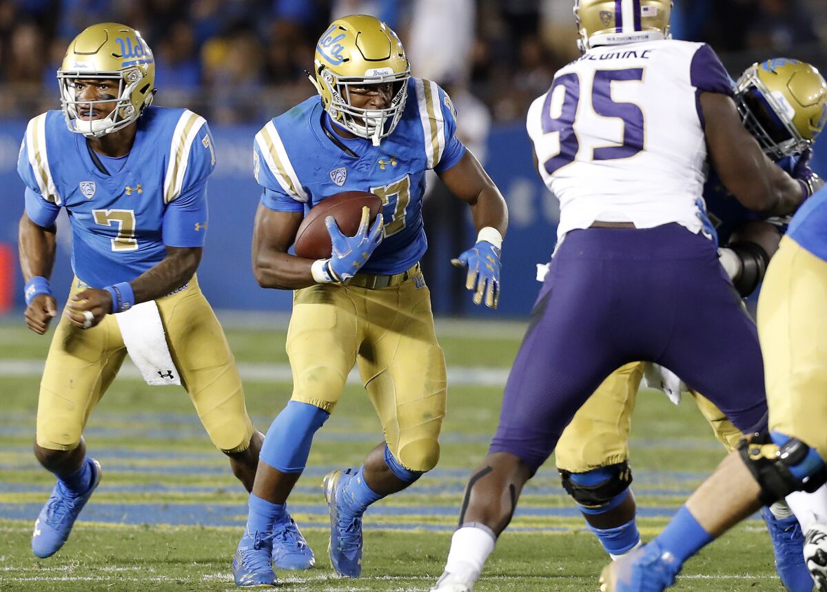 UCLA running back Joshua Kelly (27) looks for room to run against Washington in the third quarter on Saturday at the Rose Bowl.<