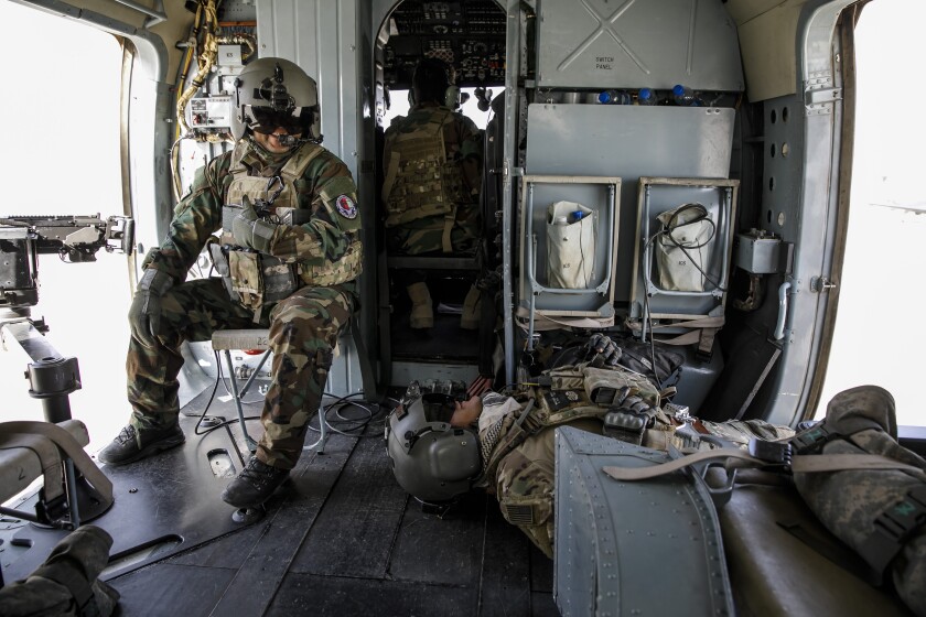 Two US military members get ready for a training flight in a Mi-17 helicopter in Kabul, Afghanistan