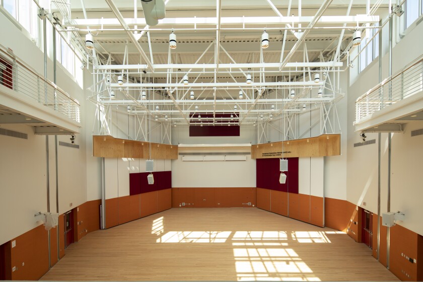 A view of an empty performance hall with sunlight streaming from a skylight above