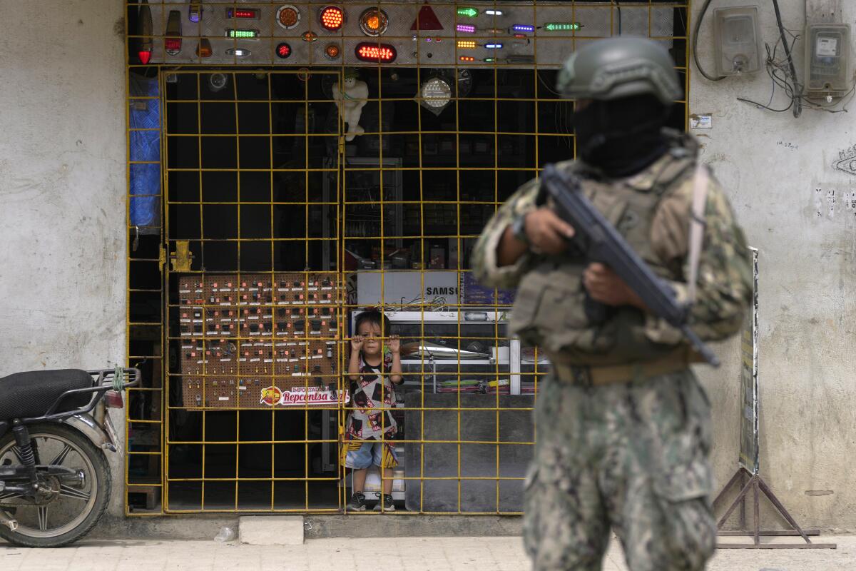 Soldier standing with firearm while child looks on in Guayaquil, Ecuador