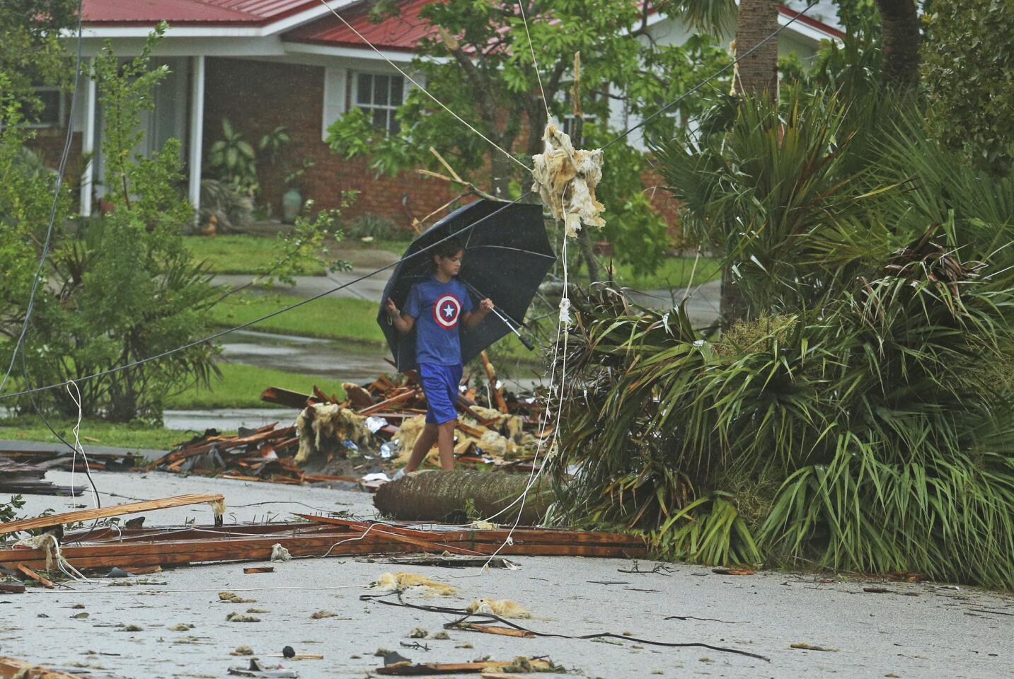 Aden Alcroix-Camper, 11, walks through debris from a second-story roof scattered over a two-block area in Palm Bay, Fla., on Sept. 10, 2017, as Hurricane Irma made landfall.