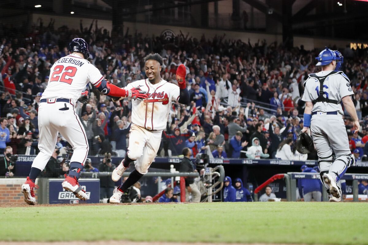 Atlanta's Ozzie Albies celebrates with Joc Pederson after scoring the winning run in the bottom of the ninth.
