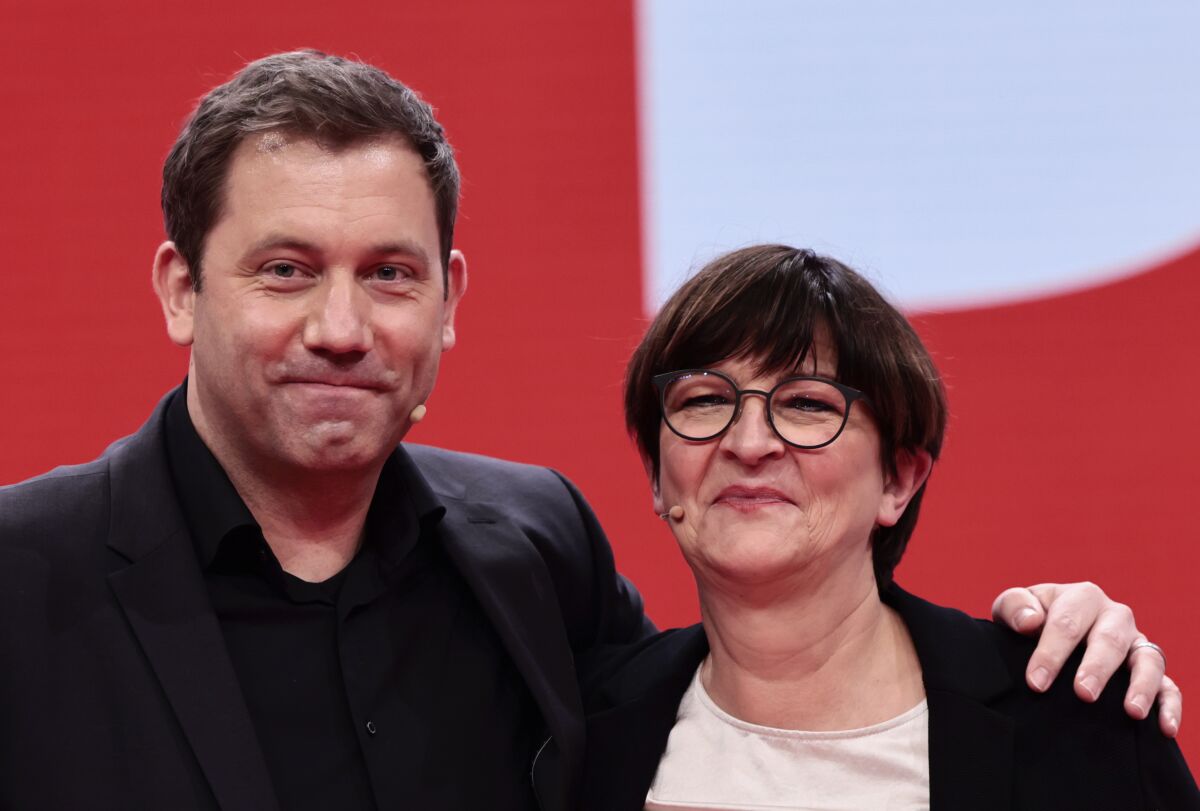 New-elected SPD co-leader Lars Klingbeil, left, poses with re-elected SPD co-leader Saskia Esken, right, pose for a photo during a hybrid party congress of Germany's Social Democratic Party (SPD) in Berlin, Germany, Dec. 11, 2021. (Hannibal Hanschke/Pool Photo via AP)