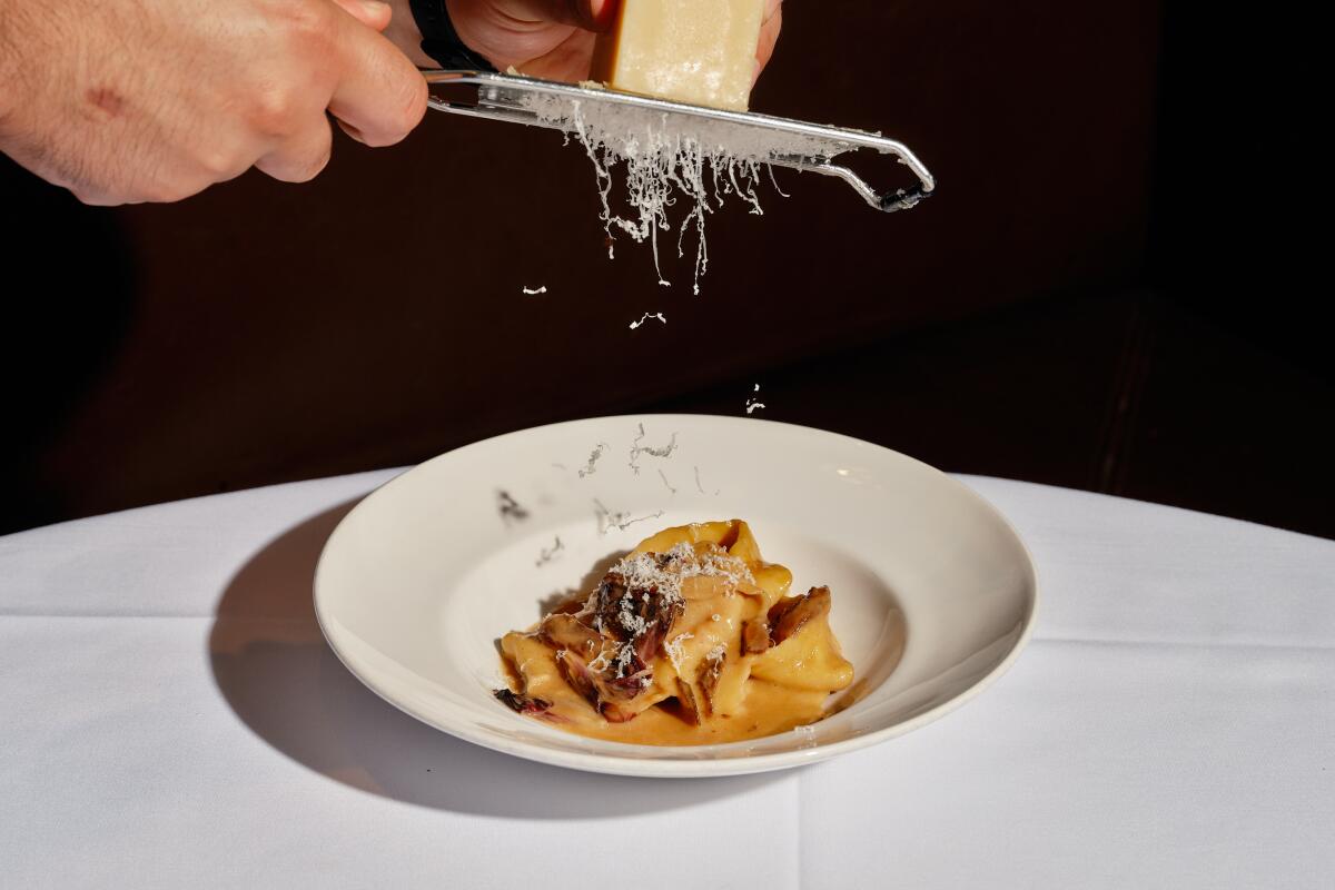 Cheese is grated over a plate of pasta