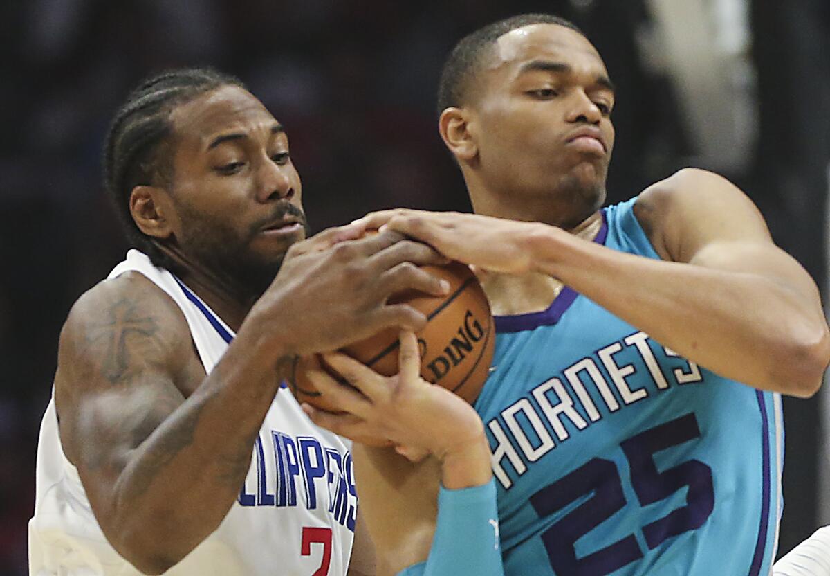 Kawhi Leonard tries to wrestle the ball from Hornets forward PJ Washington